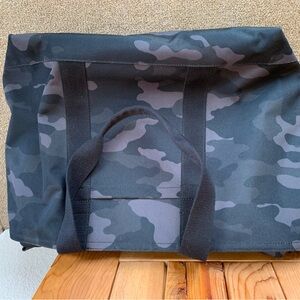Sturdy zippered canvas travel tote in green and black camouflage pattern